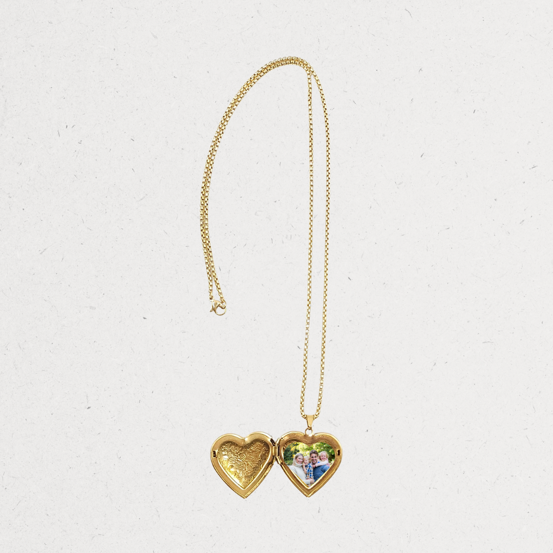 Gold heart-shaped locket necklace on a light gray background