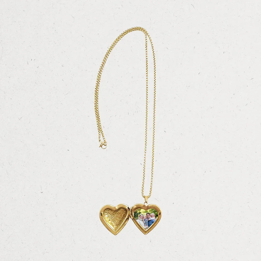 Gold heart-shaped locket necklace on a light gray background