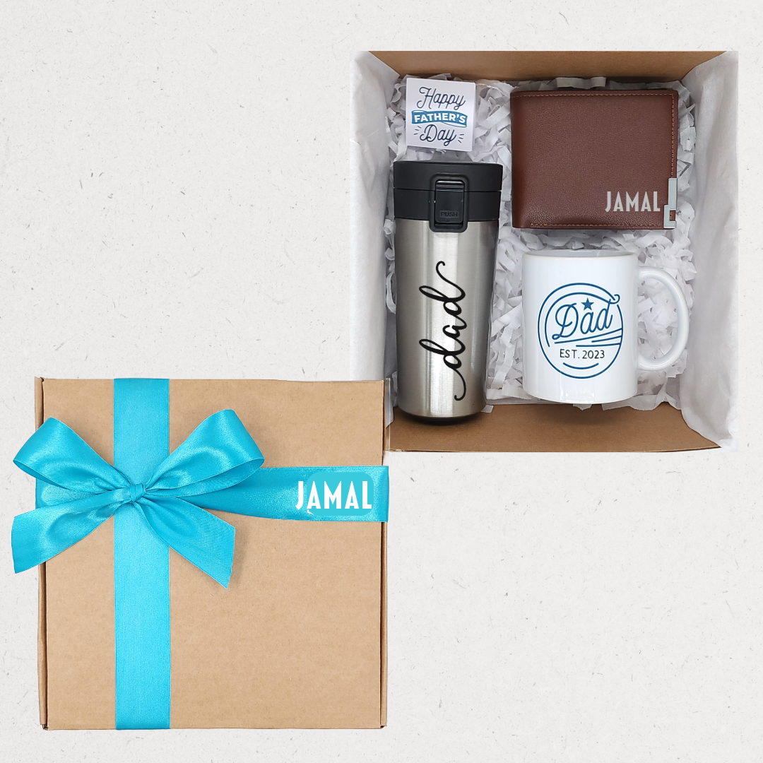 Gift set with mug, tumbler, and wallet in a box with a blue ribbon, featuring 'Happy Father's Day' card. Personalized gift box Amman Jordan