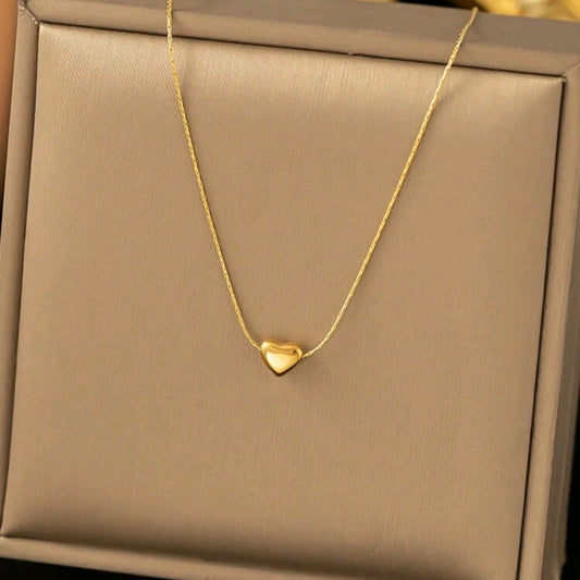 A gold-colored heart-shaped necklace presented in a black box Women’s gift box Amman Jordan