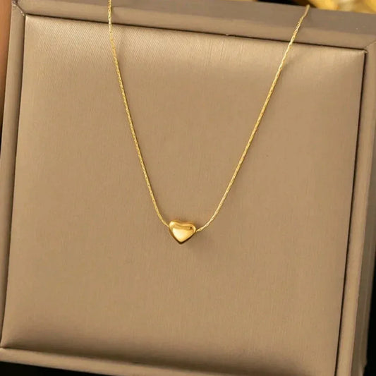 A gold-colored heart-shaped necklace presented in a black box Women’s gift box Amman Jordan