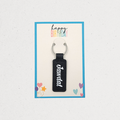 Black keychain with 'Jandal' text on a 'Happy Birthday' card with colorful text and icons. Customized gifts for all occasions Amman Jordan