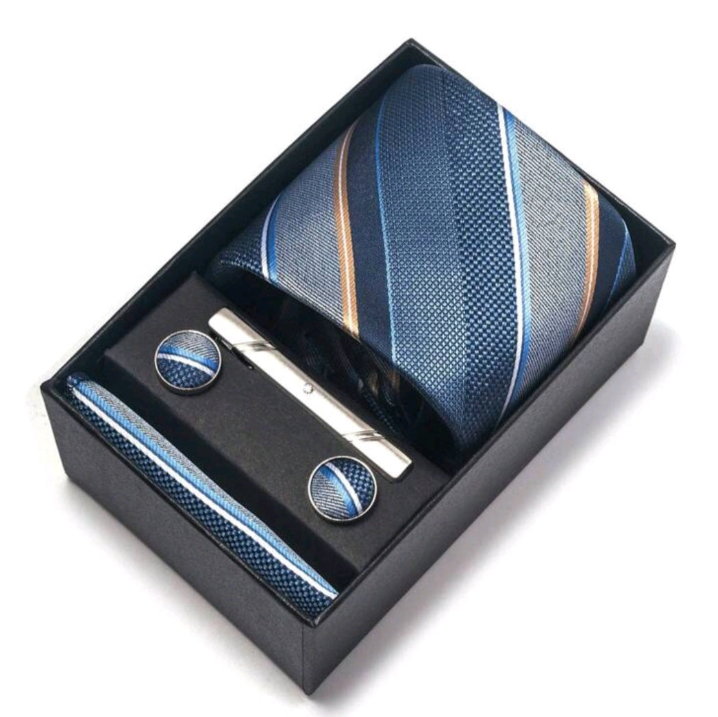 Tie, tie clip, and cufflinks set in a black box on a white background